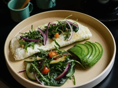 Omelette de claras relleno de espinacas y tomates cherry, con ensalada, aguacate y papas cambray